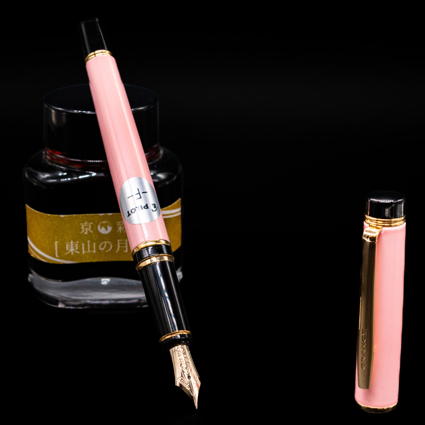Pilot Grance Fountain Pen - Pink leaning on an ink bottle uncapped showcasing the detailing on the nib.