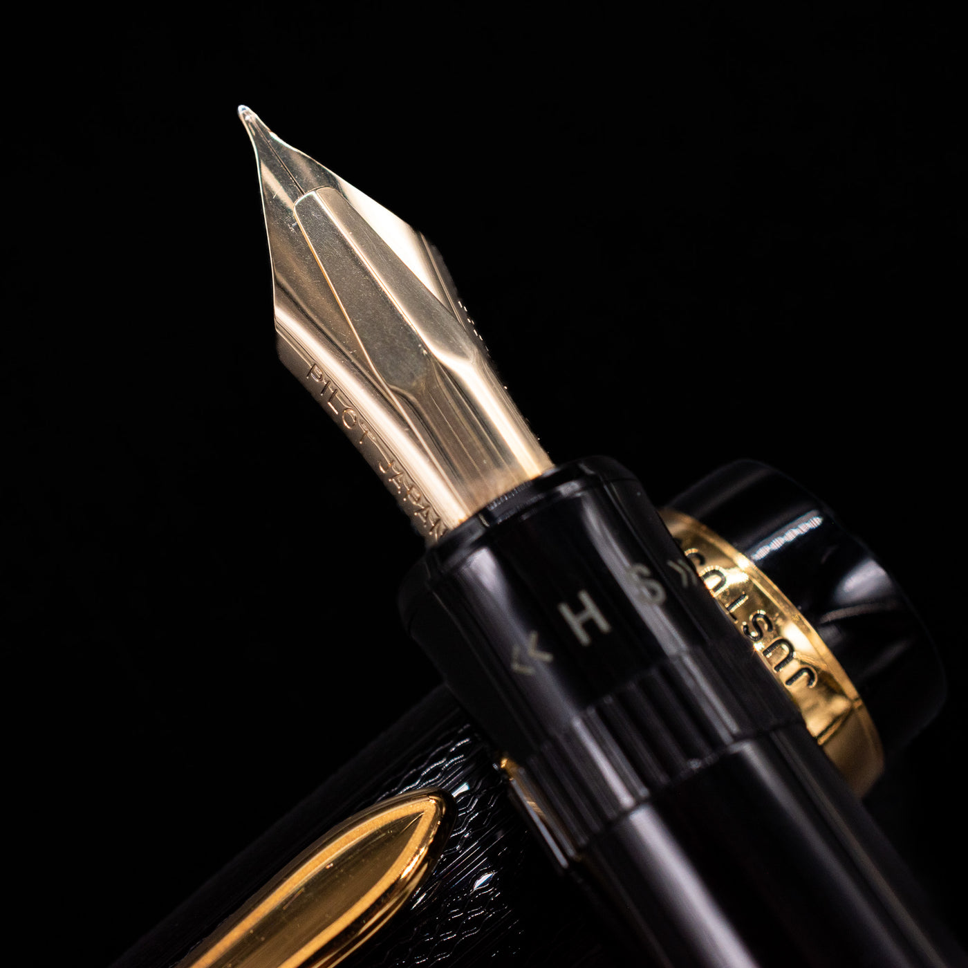 Close-up shot of the 14k gold adjustable nib on the Preowned Pilot Justus 95 Net Black fountain pen, displaying the fine engravings and precision craftsmanship.