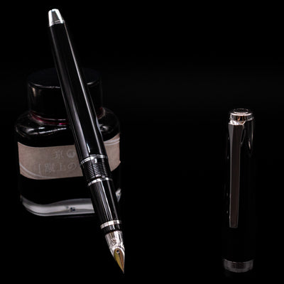 Pilot Metal Falcon Fountain Pen - Black leaning on an ink bottle uncapped showcasing the detailing on the nib.