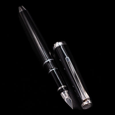 A full view of the Pilot Metal Falcon Fountain Pen - Black uncapped, with its cap laying next to the pen. 