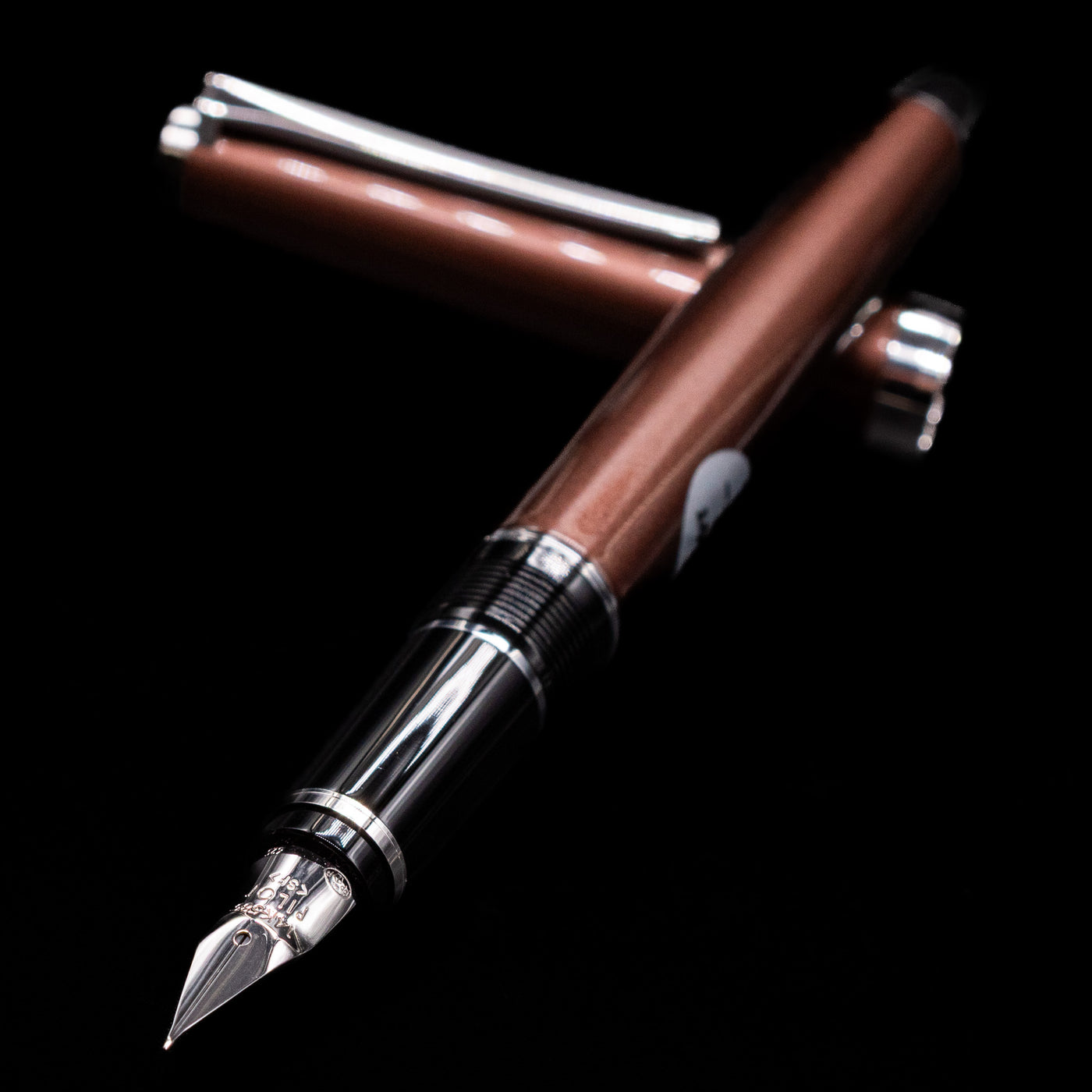 Pilot Metal Falcon Fountain Pen - Brown laying across its own cap, crossed, with a focus on the nib.