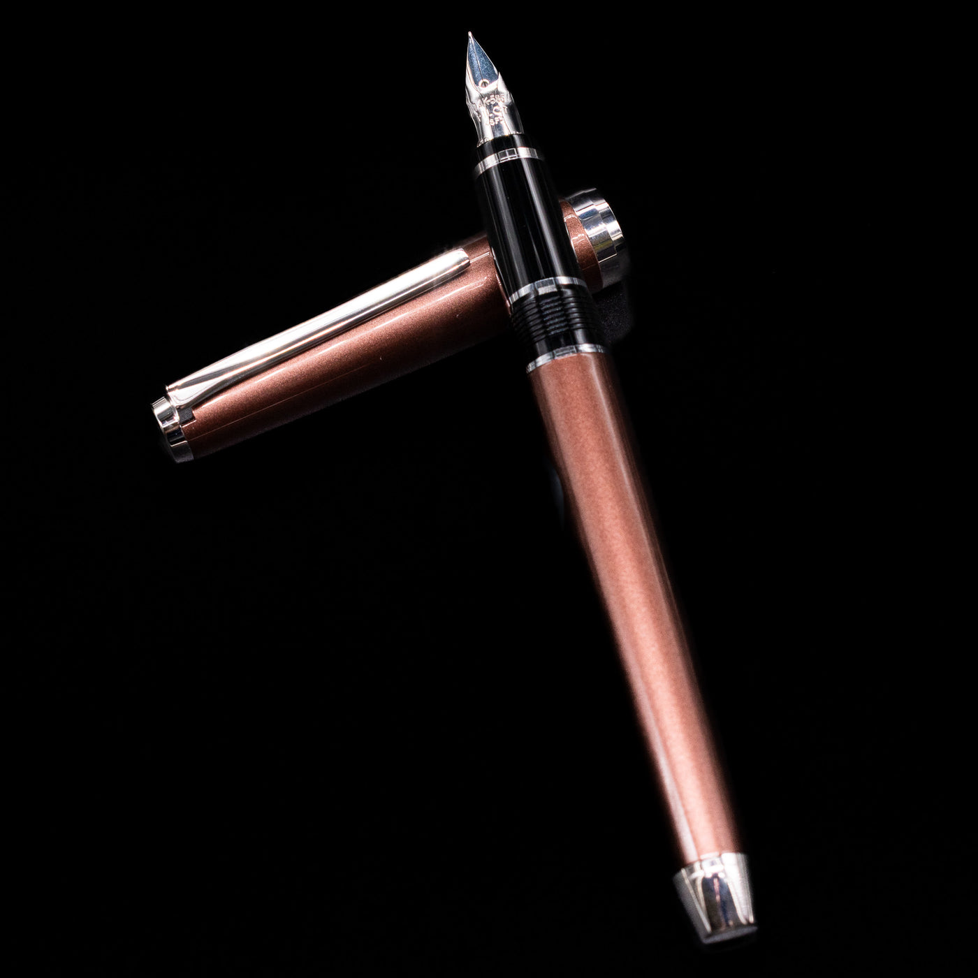 Pilot Metal Falcon Fountain Pen - Brown laying on top of its cap in a crossed position showing full view of the entire uncapped pen.