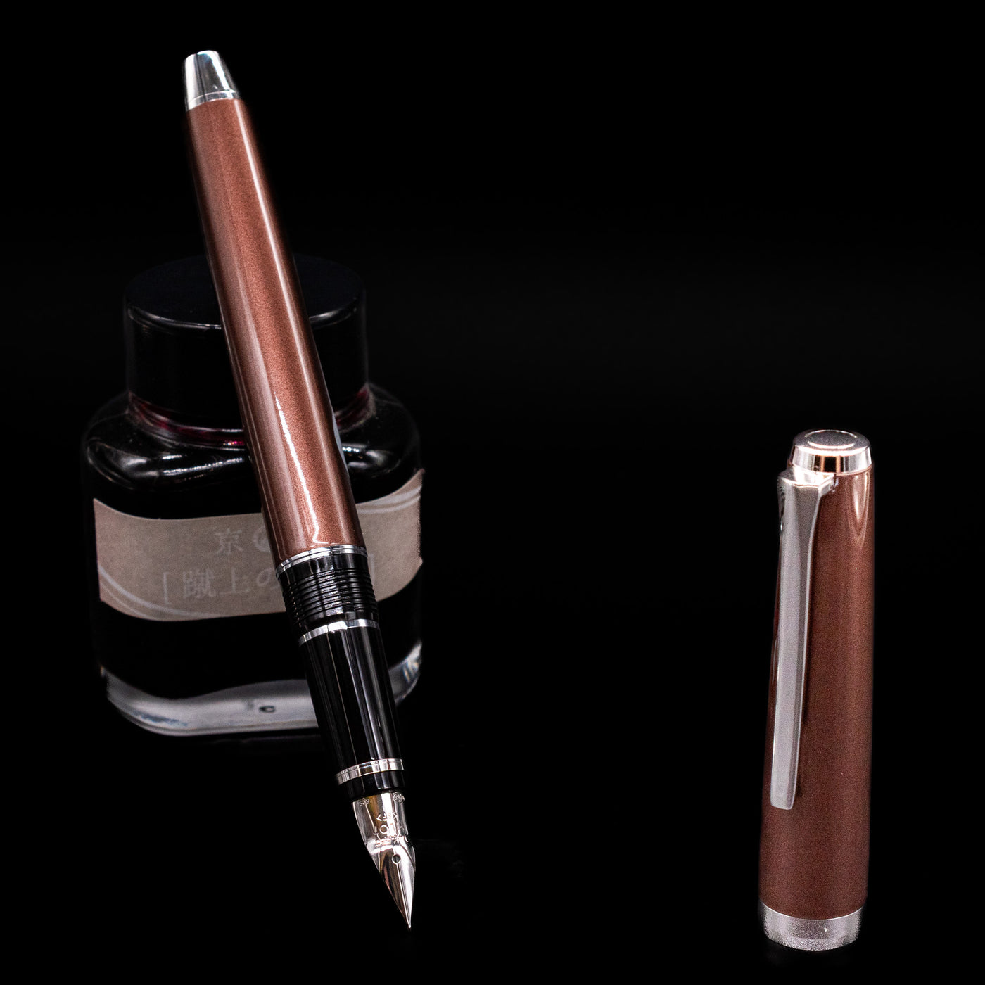Pilot Metal Falcon Fountain Pen - Brown leaning on an ink bottle uncapped showcasing the detailing on the nib.