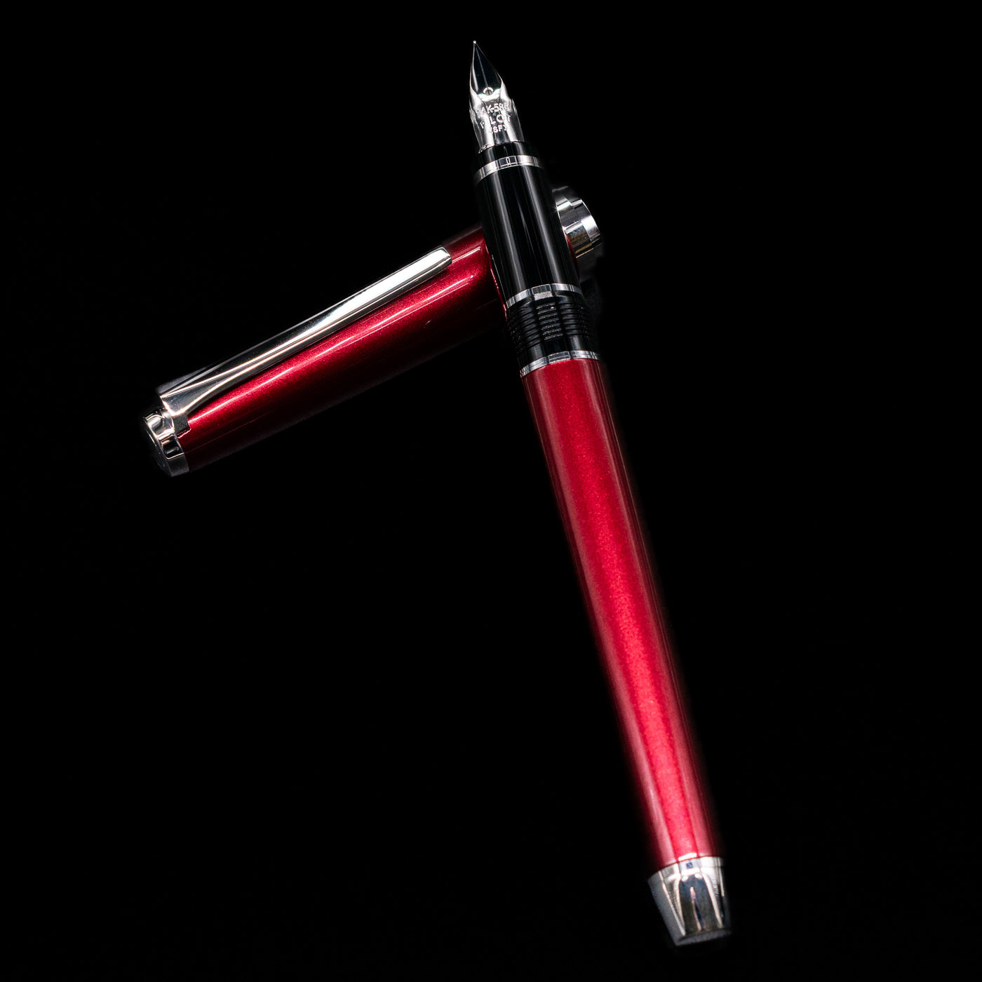 Pilot Metal Falcon Fountain Pen - Burgundy laying on top of its cap in a crossed position showing full view of the entire uncapped pen.