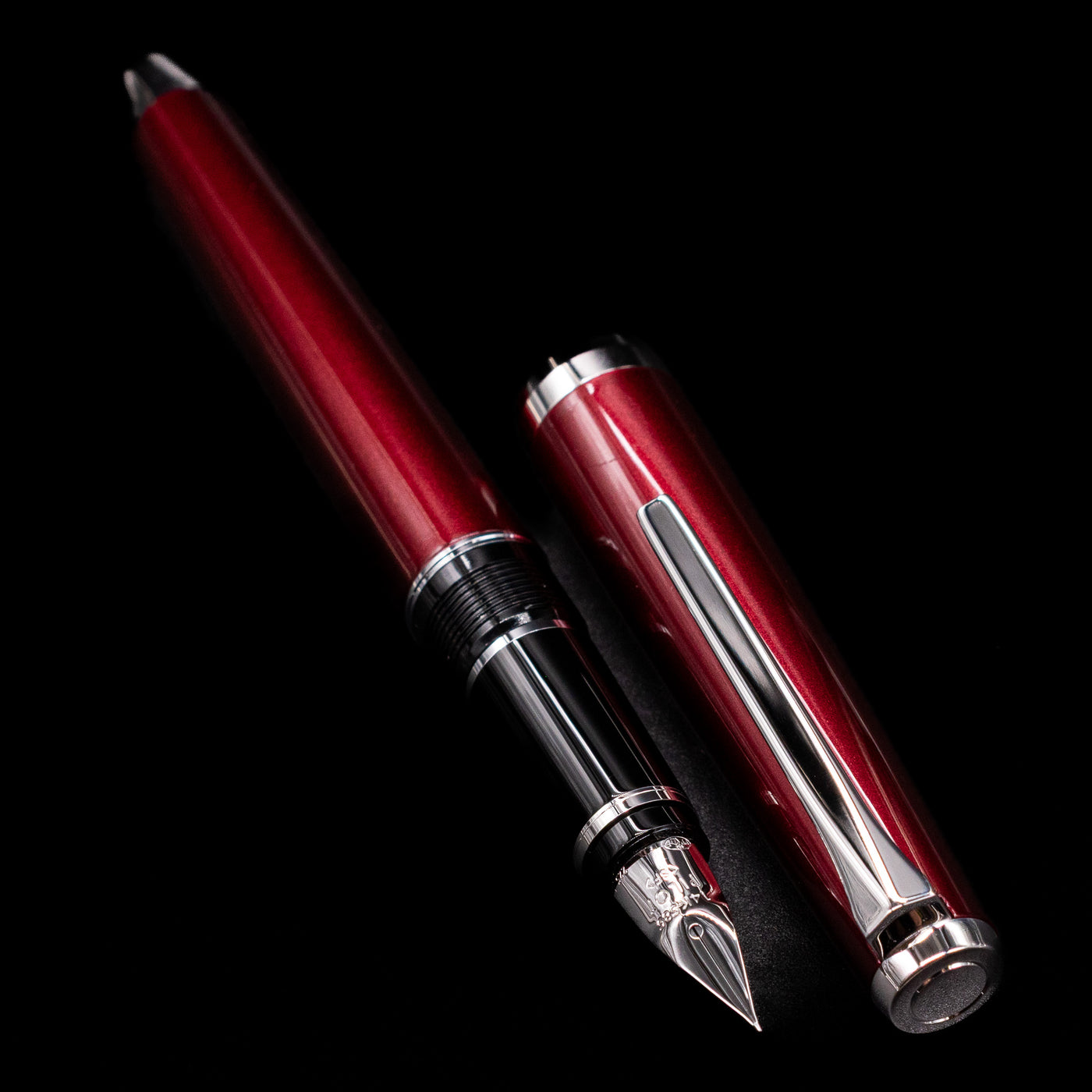 A full view of the Pilot Metal Falcon Fountain Pen - Burgundy uncapped, with its cap laying next to the pen. 