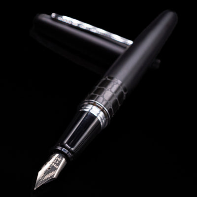 Pilot Metropolitan Fountain Pen - Crocodile laying across its own cap, crossed, with a focus on the nib.