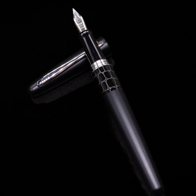 Pilot Metropolitan Fountain Pen - Crocodile laying on top of its cap in a crossed position showing full view of the entire uncapped pen.