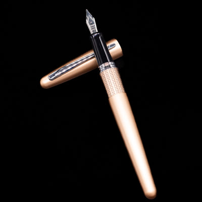 Pilot Metropolitan Fountain Pen - Gold Zig Zag laying on top of its cap in a crossed position showing full view of the entire uncapped pen.