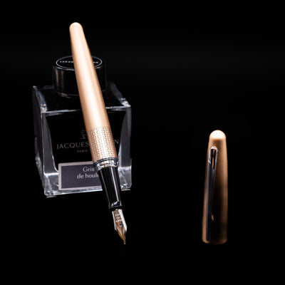 Pilot Metropolitan Fountain Pen - Gold Zig Zag leaning on an ink bottle uncapped showcasing the detailing on the nib.