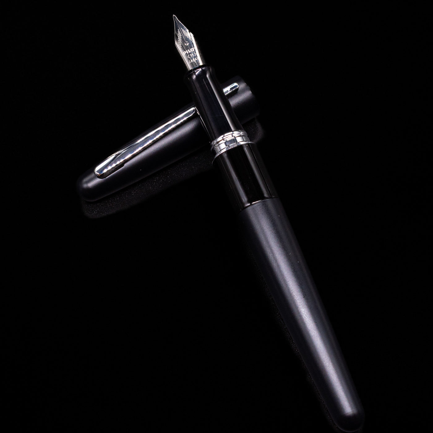 Pilot Metropolitan Fountain Pen - Plain Black laying on top of its cap in a crossed position showing full view of the entire uncapped pen.