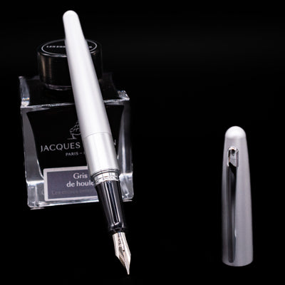 Pilot Metropolitan Fountain Pen - Plain Silver leaning on an ink bottle uncapped showcasing the detailing on the nib.