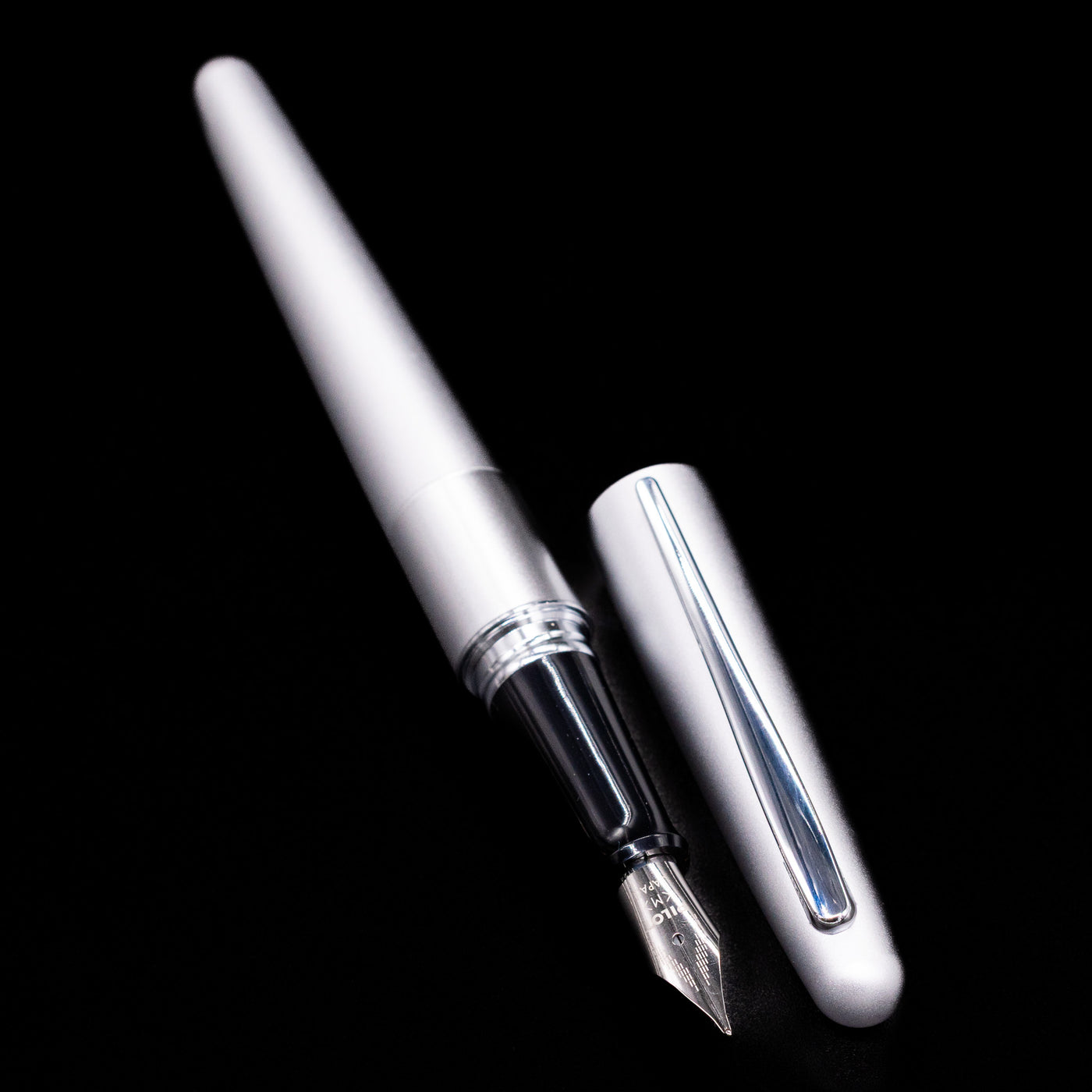  A full view of the Pilot Metropolitan Fountain Pen - Plain Silver uncapped, with its cap laying next to the pen. 