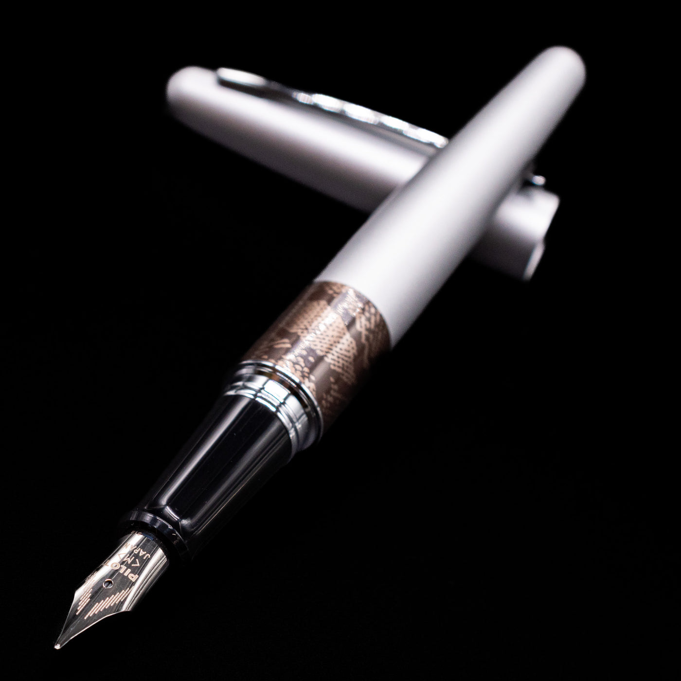 Pilot Metropolitan Fountain Pen - Python laying across its own cap, crossed, with a focus on the nib.