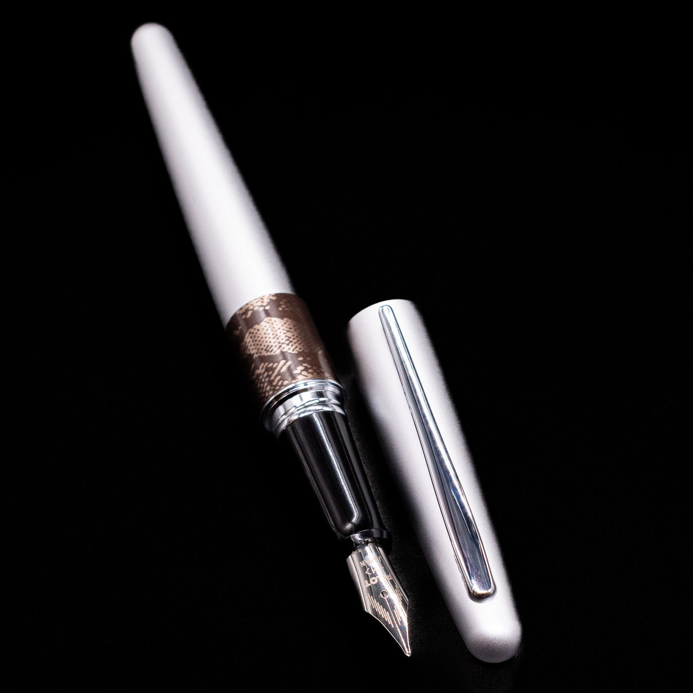 A full view of the Pilot Metropolitan Fountain Pen - Python uncapped, with its cap laying next to the pen. 