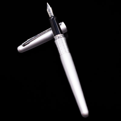 Pilot Metropolitan Fountain Pen - Silver with Dots laying on top of its cap in a crossed position showing full view of the entire uncapped pen.
