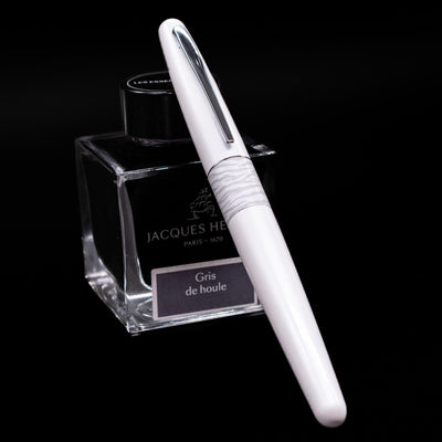 Pilot Metropolitan Fountain Pen - White Tiger capped, leaning against an ink bottle. 