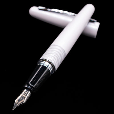 Pilot Metropolitan Fountain Pen - White Tiger laying across its own cap, crossed, with a focus on the nib.