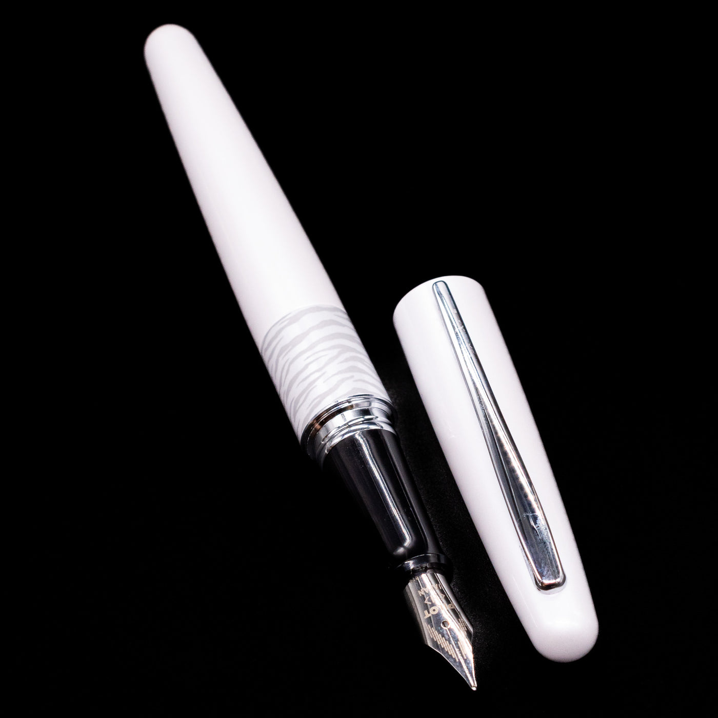 A full view of the Pilot Metropolitan Fountain Pen - White Tiger uncapped, with its cap laying next to the pen. 