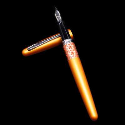 Pilot Metropolitan MR Retro Pop Fountain Pen - Orange laying on top of its cap in a crossed position showing full view of the entire uncapped pen.