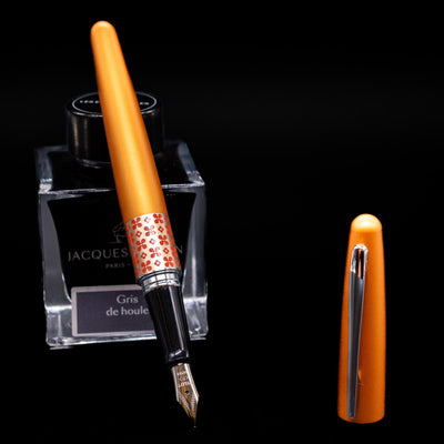 Pilot Metropolitan MR Retro Pop Fountain Pen - Orange leaning on an ink bottle uncapped showcasing the detailing on the nib.