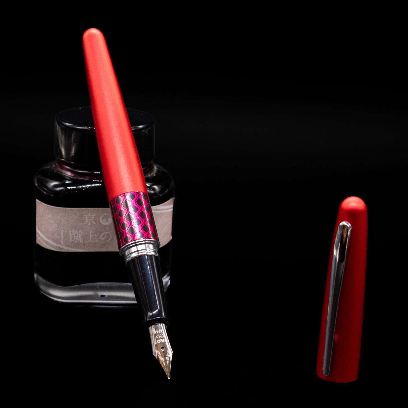 Pilot Metropolitan MR Retro Pop Fountain Pen - Red leaning on an ink bottle uncapped showcasing the detailing on the nib.