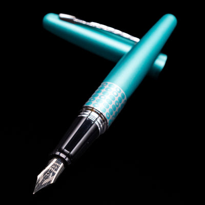 Pilot Metropolitan MR Retro Pop Fountain Pen - Turquoise laying across its own cap, crossed, with a focus on the nib.