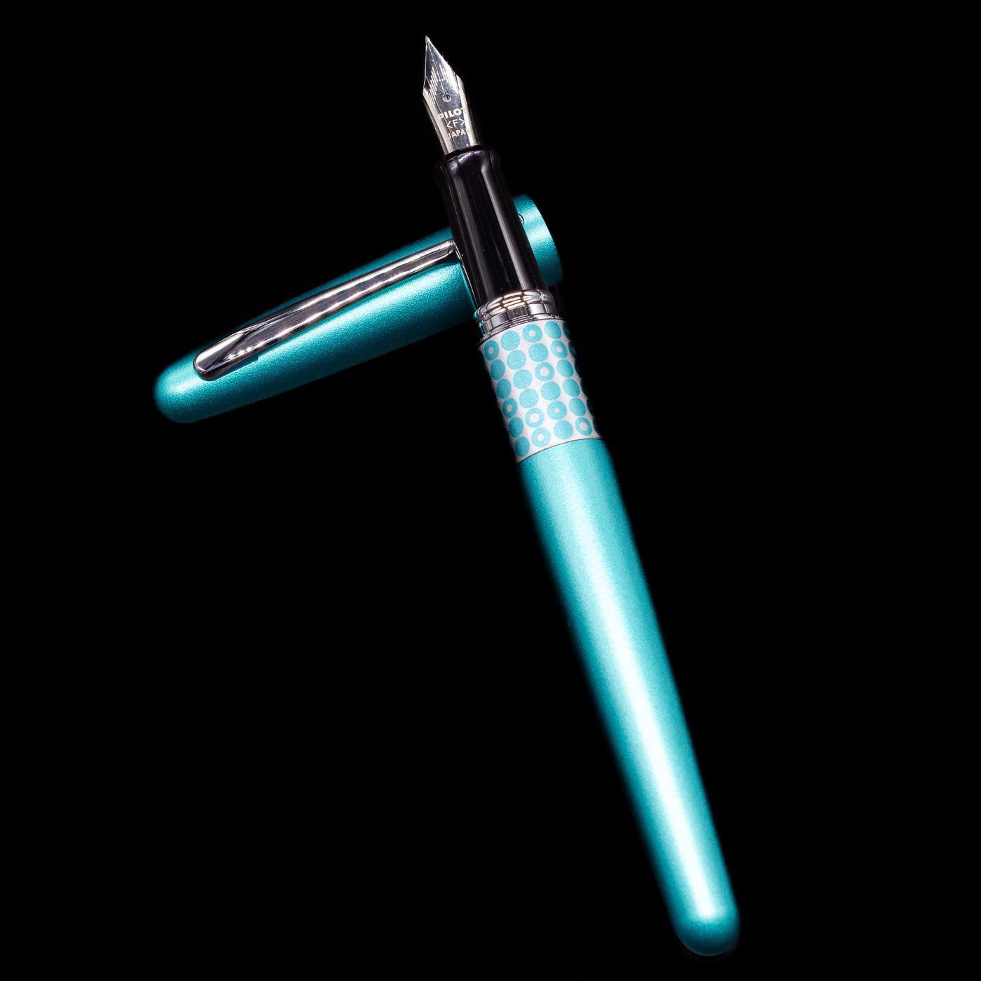 Pilot Metropolitan MR Retro Pop Fountain Pen - Turquoise laying on top of its cap in a crossed position showing full view of the entire uncapped pen.