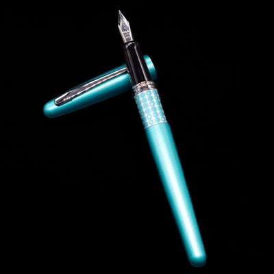 Pilot Metropolitan MR Retro Pop Fountain Pen - Turquoise laying on top of its cap in a crossed position showing full view of the entire uncapped pen.