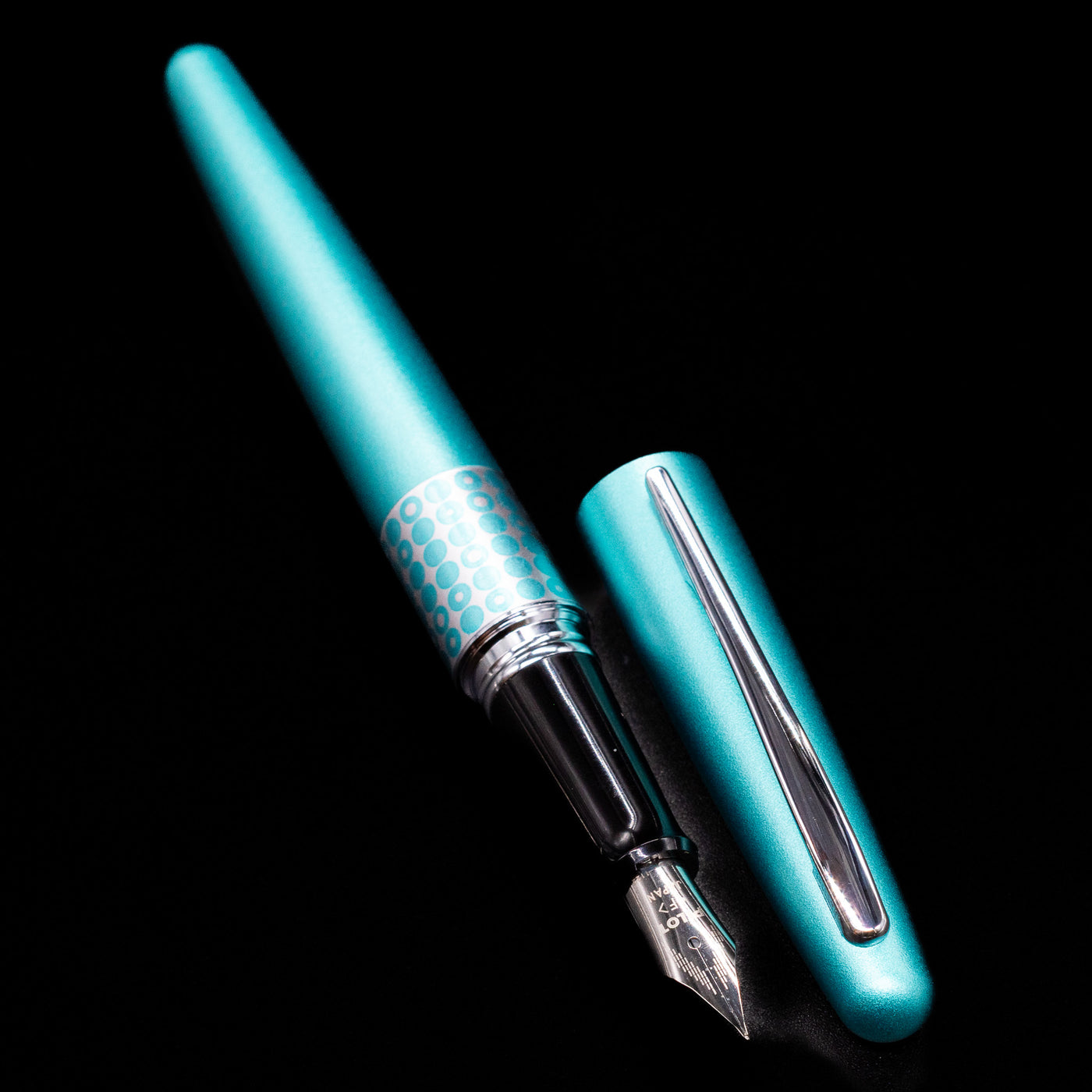 A full view of the Pilot Metropolitan MR Retro Pop Fountain Pen - Turquoise uncapped, with its cap laying next to the pen. 