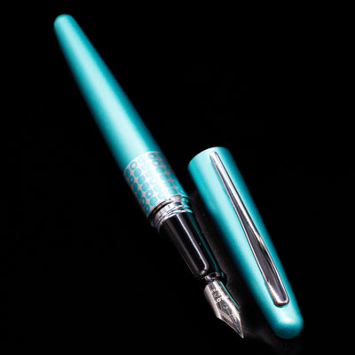 A full view of the Pilot Metropolitan MR Retro Pop Fountain Pen - Turquoise uncapped, with its cap laying next to the pen. 