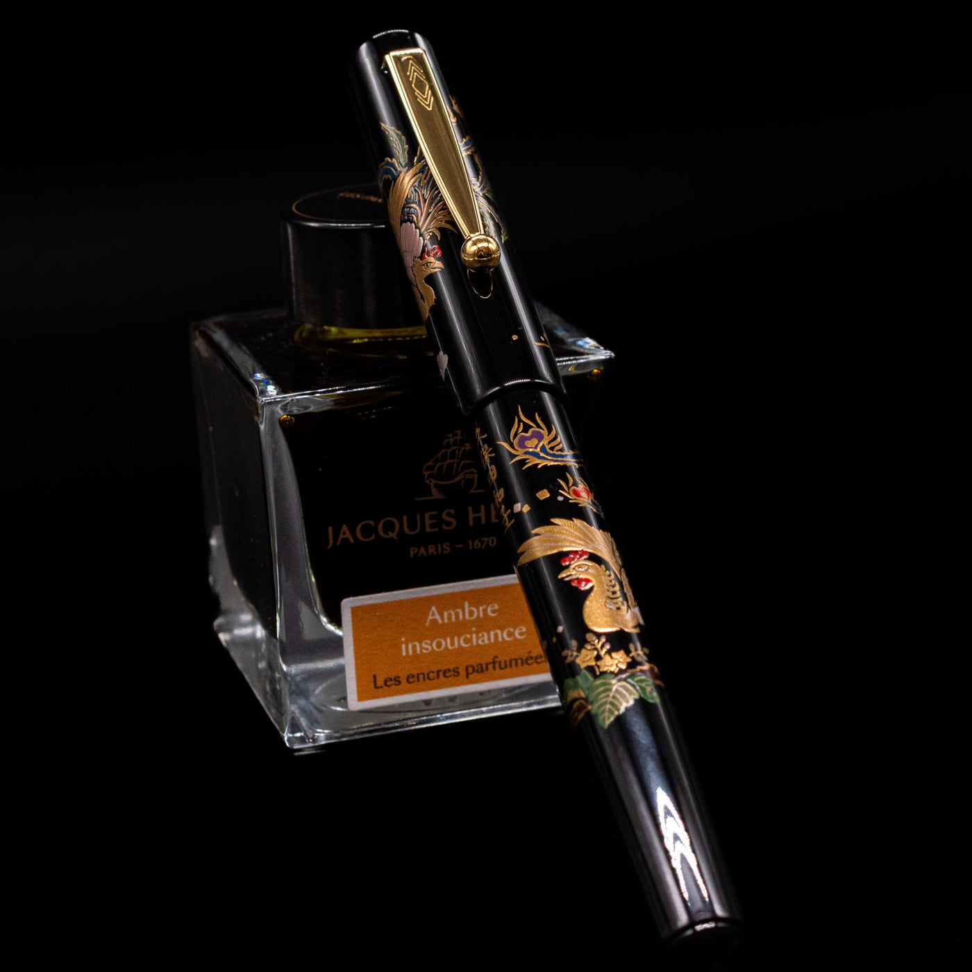 Pilot Namiki Sokuikinen HouOu (Double Phoenix) Maki-e Fountain Pen by Kyusai Yoshida - Preowned capped, leaning against an ink bottle. 