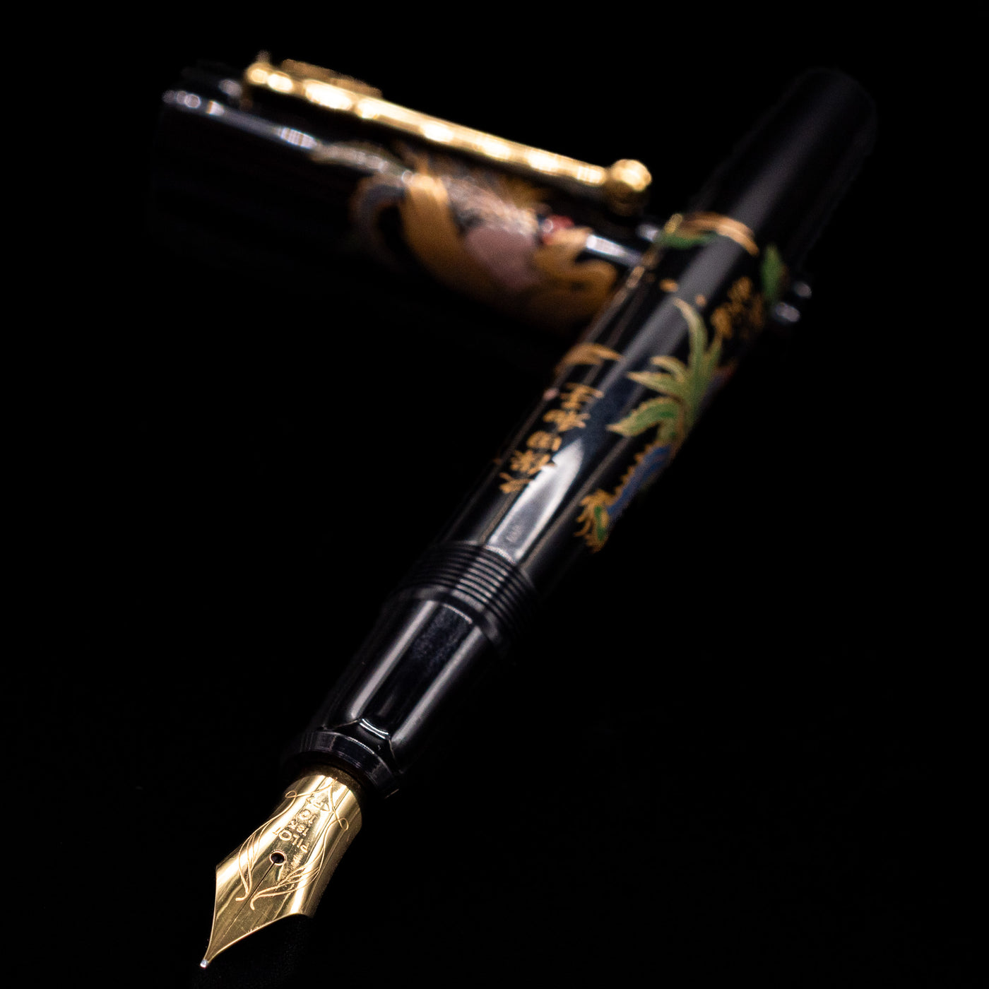  Pilot Namiki Sokuikinen HouOu (Double Phoenix) Maki-e Fountain Pen by Kyusai Yoshida - Preowned laying across its own cap, crossed, with a focus on the nib.