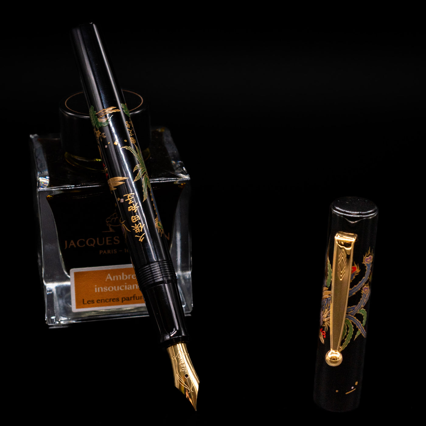 Pilot Namiki Sokuikinen HouOu (Double Phoenix) Maki-e Fountain Pen by Kyusai Yoshida - Preowned leaning on an ink bottle uncapped showcasing the detailing on the nib.