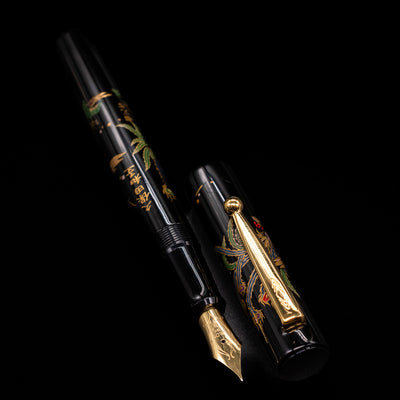  A full view of the Pilot Namiki Sokuikinen HouOu (Double Phoenix) Maki-e Fountain Pen by Kyusai Yoshida - Preowned uncapped, with its cap laying next to the pen. 