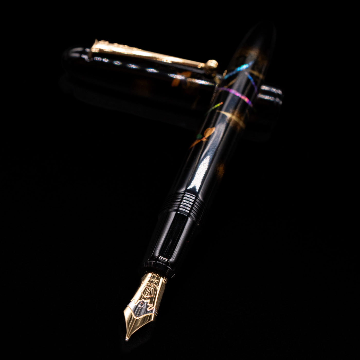 Pilot Namiki Yukari Maki-e Fountain Pen - Firefly laying across its own cap, crossed, with a focus on the nib.