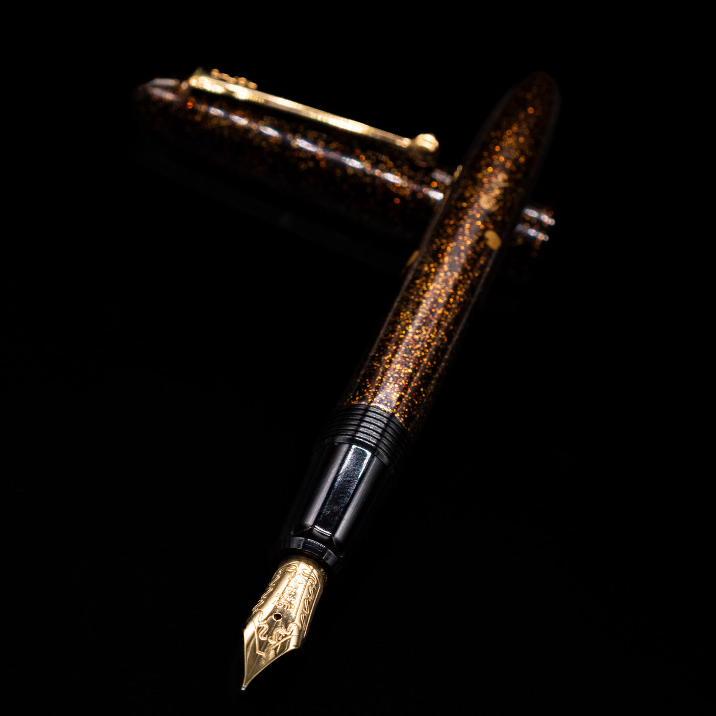 Pilot Namiki Yukari Maki-e Fountain Pen - Sakura Fubuki laying across its own cap, crossed, with a focus on the nib.