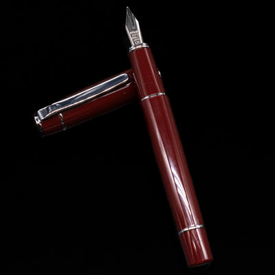 Pilot Prera Fountain Pen - Cinnamon Brown laying on top of its cap in a crossed position showing full view of the entire uncapped pen.