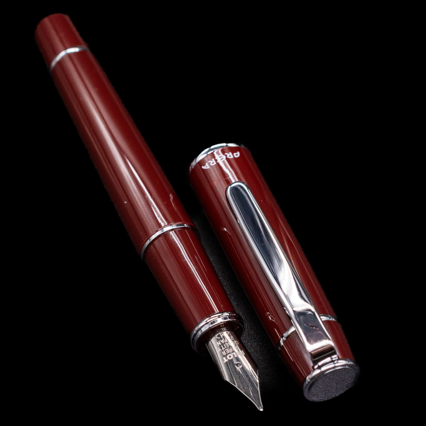 A full view of the Pilot Prera Fountain Pen - Cinnamon Brown uncapped, with its cap laying next to the pen. 