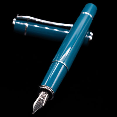 Pilot Prera Fountain Pen - Empress Teal laying across its own cap, crossed, with a focus on the nib.