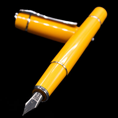 Pilot Prera Fountain Pen - Honey Yellow laying across its own cap, crossed, with a focus on the nib.