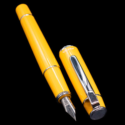  A full view of the Pilot Prera Fountain Pen - Honey Yellow uncapped, with its cap laying next to the pen. 