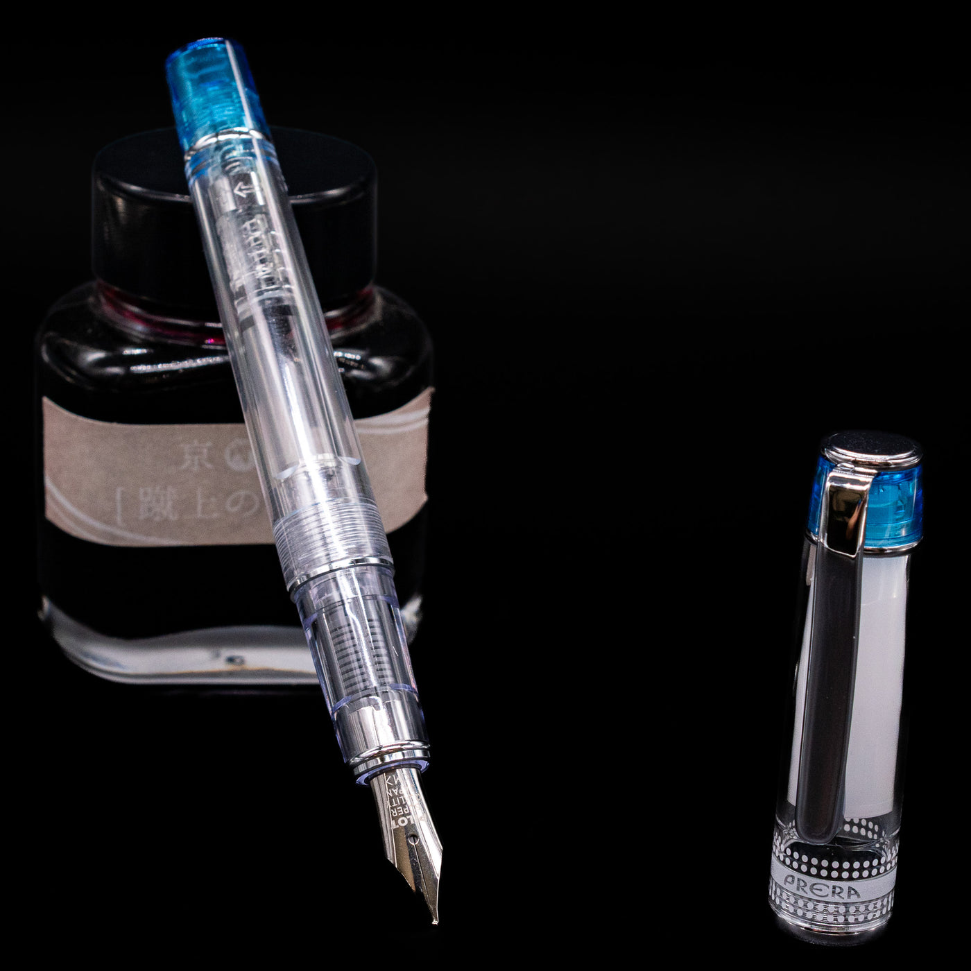 Pilot Prera Fountain Pen - Light Blue leaning on an ink bottle uncapped showcasing the detailing on the nib.