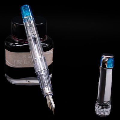 Pilot Prera Fountain Pen - Light Blue leaning on an ink bottle uncapped showcasing the detailing on the nib.