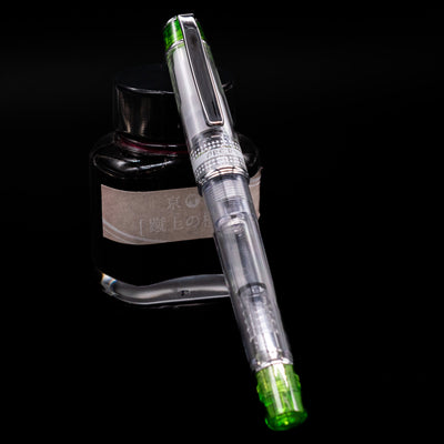 Pilot Prera Fountain Pen - Light Green capped, leaning against an ink bottle. 