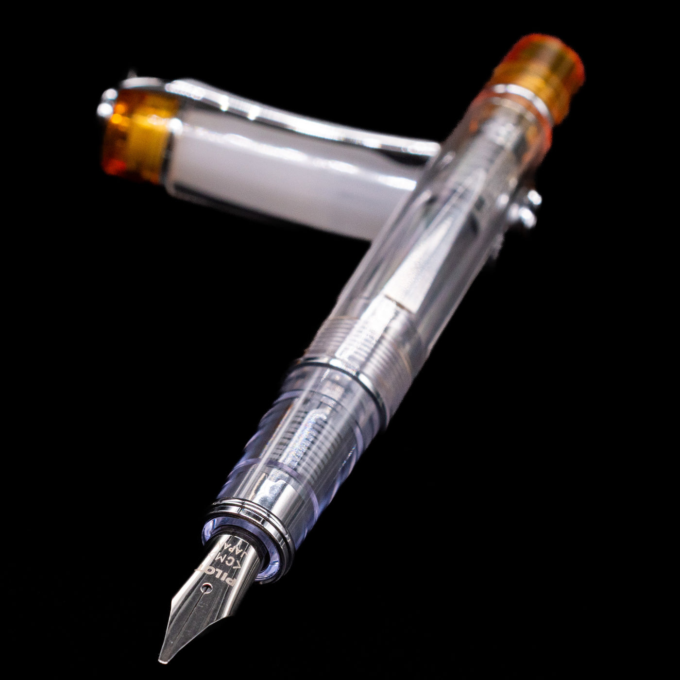 Pilot Prera Fountain Pen - Orange laying across its own cap, crossed, with a focus on the nib.