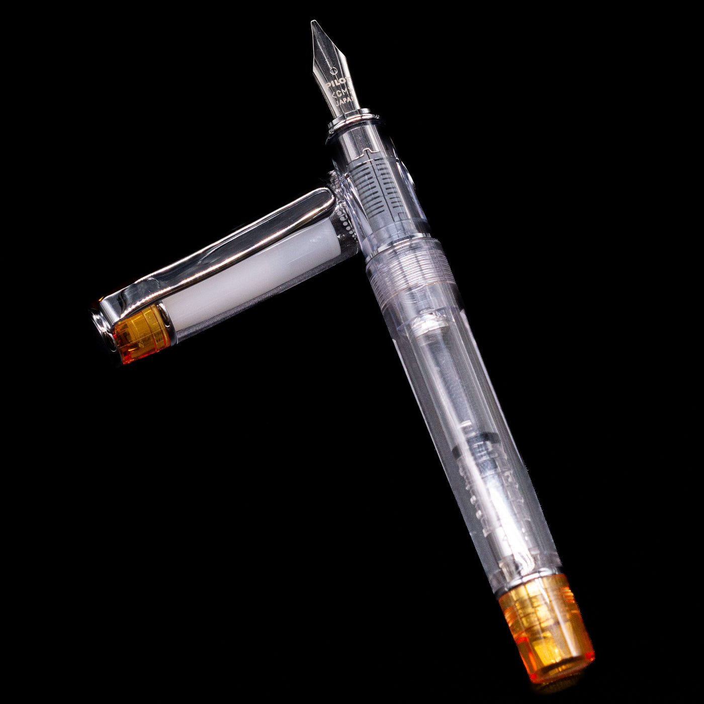 Pilot Prera Fountain Pen - Orange laying on top of its cap in a crossed position showing full view of the entire uncapped pen.