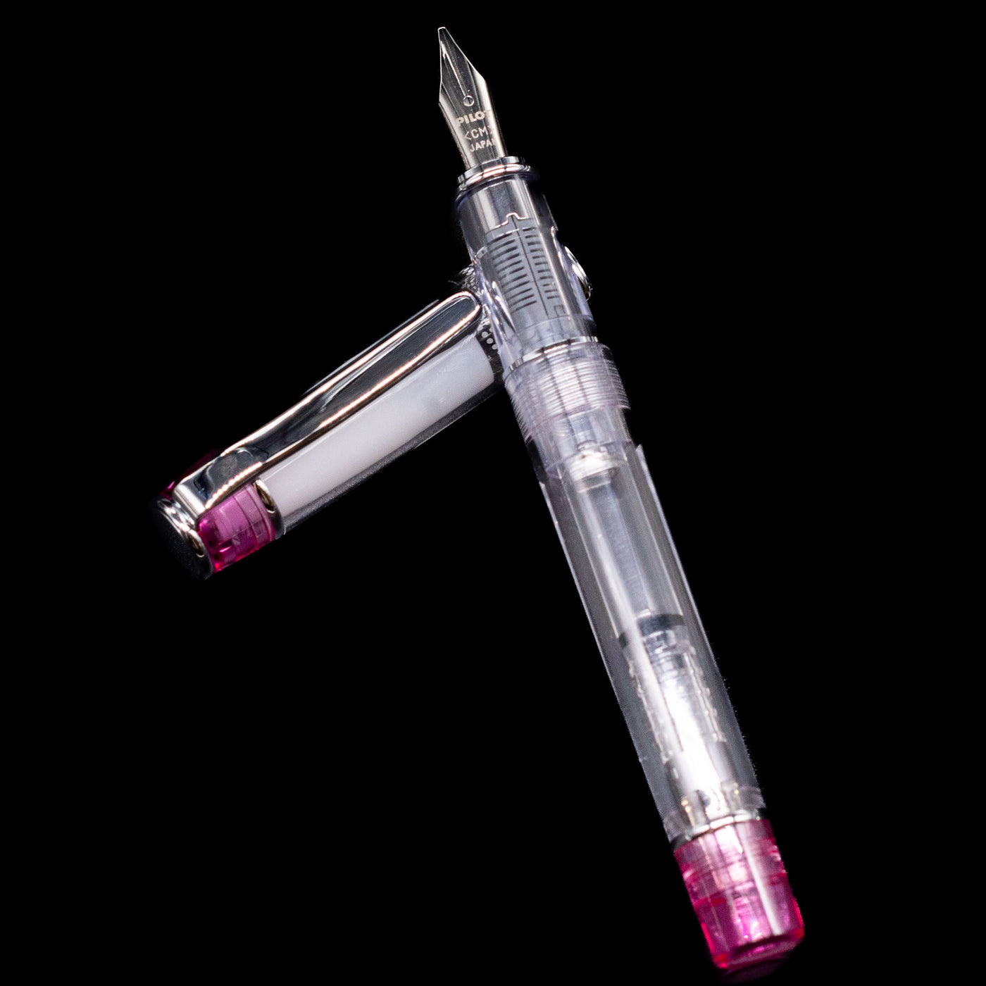 Pilot Prera Fountain Pen - Pink laying on top of its cap in a crossed position showing full view of the entire uncapped pen.