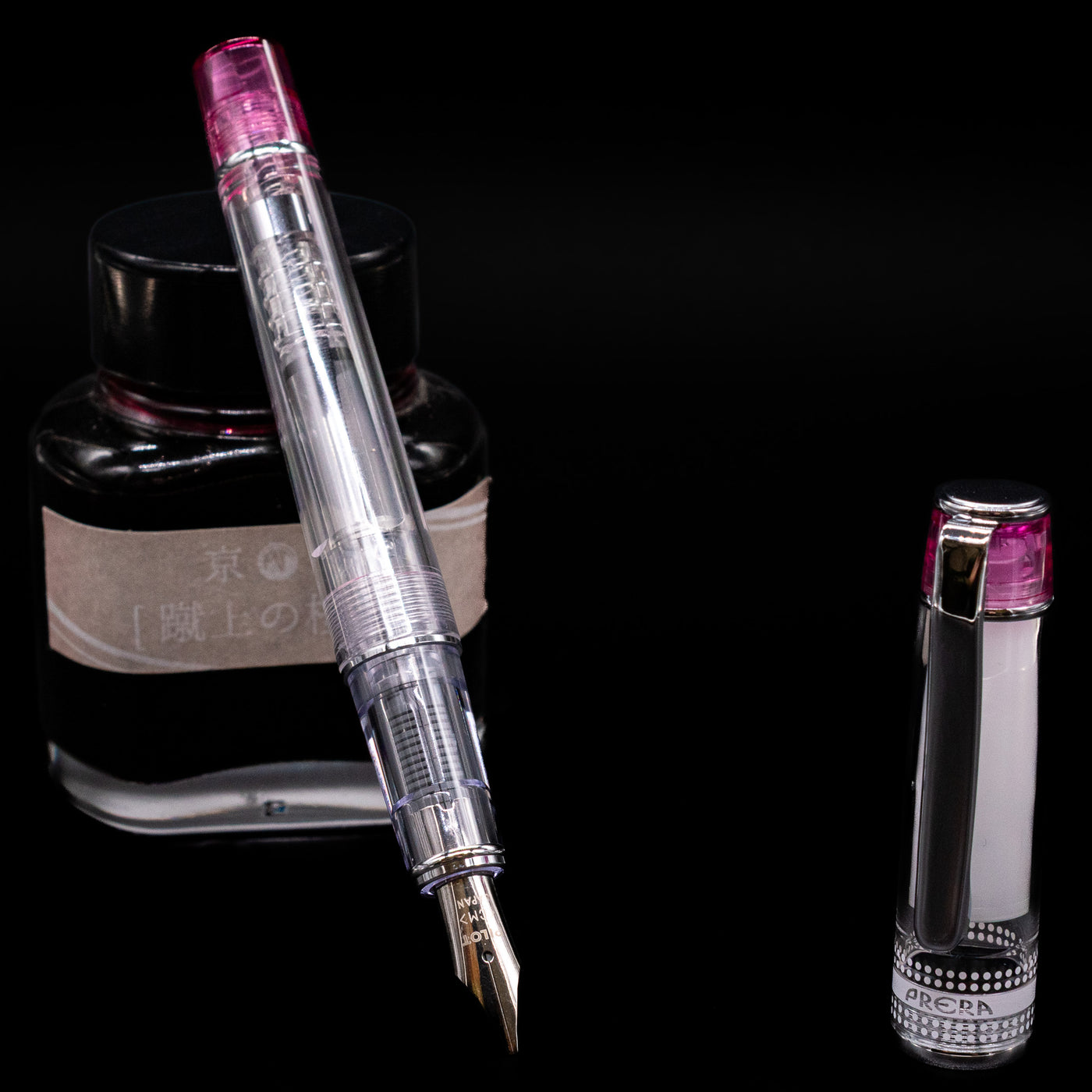Pilot Prera Fountain Pen - Pink leaning on an ink bottle uncapped showcasing the detailing on the nib.