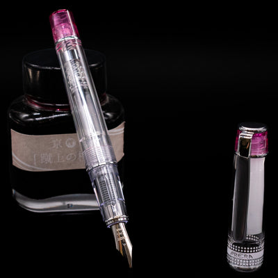 Pilot Prera Fountain Pen - Pink leaning on an ink bottle uncapped showcasing the detailing on the nib.