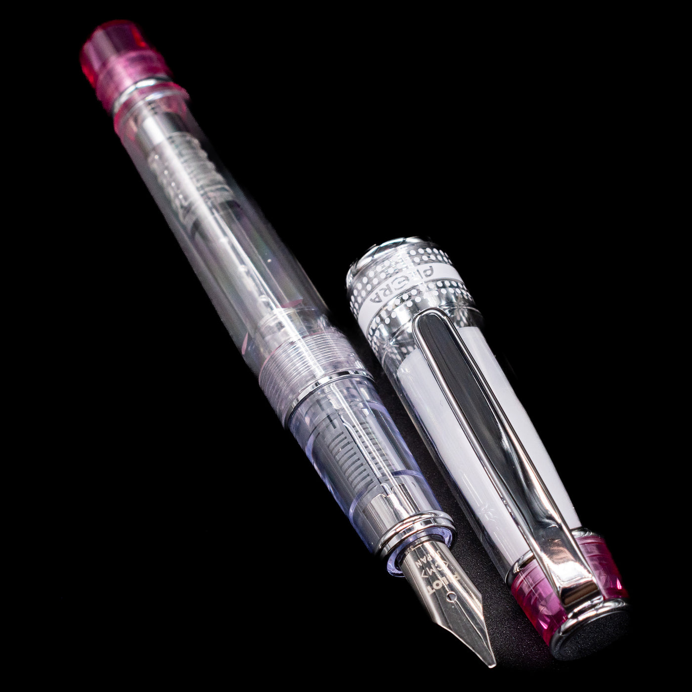 A full view of the Pilot Prera Fountain Pen - Pink uncapped, with its cap laying next to the pen. 